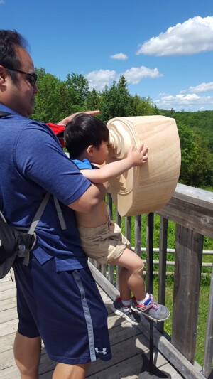 The coin operated binoculars house a tablet which plays an original animated short, created out of hundreds of watercolor panels. Child examining the Landmarks 2017 sculpture