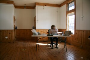 I am working at a desk in the middle of a well-lit room.