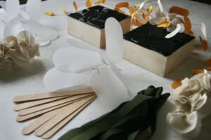 Detail of two small, square, acrylic paintings surrounded by mixed media sculptures.