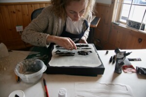 Applying thick acrylic shapes to the canvas with palette knife.