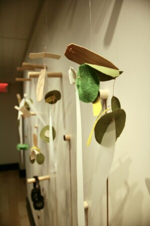 A detail image of one mixed-media tactile sculpture with the remaining installation in the background.