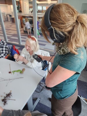 Dawn recording an elderly woman feeling the textures of a leaf