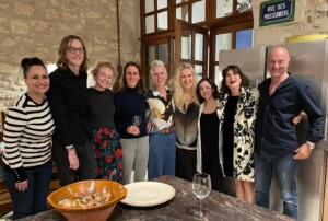 A group of artists and the residency hosts posing together for a photo in the kitchen.