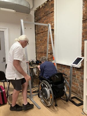 David and Kim testing out Haptic Voices by resting Kim's head on vibrating transducers.