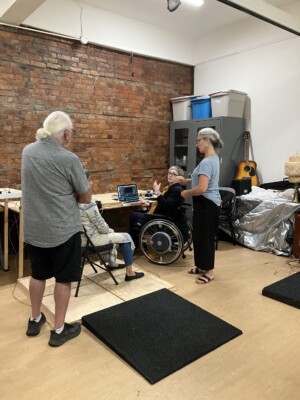 Kim, Debbie, Marsha, and David gathered to discuss Kim's next project featuring a vibrating wheelchair platform.