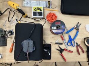 Many tools laid out on the table to create a vibration pillow with a laptop sleeve.