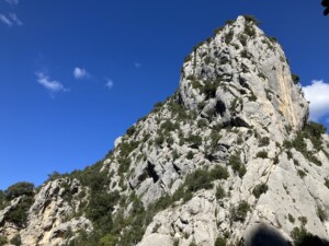 A dramatic view of a mountain peak against a bright blue sky.