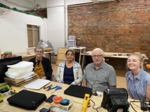 Kim, Marsha, David, and myself at a table with equipment on the surface.